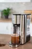 Unold Express Ava silber-weiß auf Holzplatte, neben French Press, Kaffeetasse, Glas Bohnen & losen B Produktbild-Vorschau