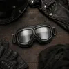 Paar schwarze Vintage-Motorradbrillen mit klaren Gläsern, umgeben von anderen Biker-Zubehör wie einem Leder Anteprima dell’immagine prodotto