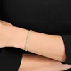 A close-up shot of a person's wrist wearing a delicate gold bracelet with clear stones. Anteprima dell’immagine prodotto