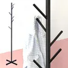 A black metal coat rack with a checkered shirt hanging on it, set against a white and pink background. Voir les images du produit