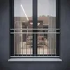 A French balcony railing made of stainless steel is shown in front of a window, reflecting an interior living space. Podgląd zdjęcia produktu