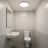 A clean, modern bathroom with a sink, toilet, and a ceiling light. Produktbild-Vorschau