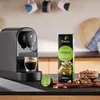A coffee machine with a cup of espresso, a box of coffee capsules, and some pistachios and chocolate pieces. Podgląd zdjęcia produktu