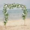 A wedding arch decorated with flowers on a beach with the ocean in the background. Náhled obrázku produktu