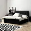 A black boxspring bed with white bedding and a patterned pillow in a bedroom setting. Produktbild-Vorschau