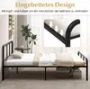 A black metal bed frame with a mattress and bedding in a room with a window and plants. Voir les images du produit