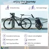 A bicycle is attached to a trolley with a body of water and buildings in the background. Produktbild-Vorschau
