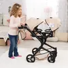 A young girl is playing with a twin doll stroller in a bedroom. Produktbild-Vorschau