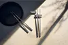 A set of chopsticks and a chopstick rest are arranged on a textured surface with dramatic shadows. Náhled obrázku produktu
