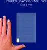 A hand is shown next to a sheet of small blue labels, indicating the size of the labels. Náhled obrázku produktu