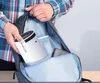 A person is placing a white cylindrical device into a backpack. Náhled obrázku produktu