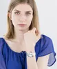 A woman wearing a blue top and a silver watch. Náhľad obrázku produktu