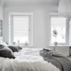 A bedroom scene with a bed and two windows. Produktbild-Vorschau