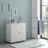 A bathroom scene with a white cabinet, a towel rack with a blue towel, and decorative frames on the wall. Náhled obrázku produktu