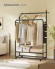 A clothing rack with clothes and accessories in a bedroom setting. Produktbild-Vorschau