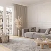 A modern living room with a large gray sofa, a round wooden coffee table, and a patterned rug. Anteprima dell’immagine prodotto
