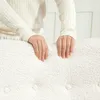 A person's hands resting on a textured, cream-colored surface. Anteprima dell’immagine prodotto