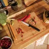 A kitchen scene with ingredients and a knife on a cutting board. Podgląd zdjęcia produktu