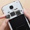 A person is inserting a microSD card into a smartphone. Anteprima dell’immagine prodotto