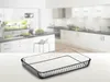 A clear glass baking dish is placed on a white surface in front of a blurred kitchen background. Produktbild-Vorschau