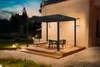 A modern outdoor living space with a pergola, dining set, and sofa on a wooden deck at dusk. Produktbild-Vorschau