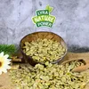 A bowl of dried peas, with a wooden scoop and some decorative elements, against a textured background. Produktbild-Vorschau