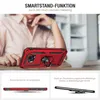 A person is holding a red smartphone case with a ring stand on a table. Produktbild-Vorschau