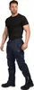 A man wearing navy work pants and a black t-shirt, posing against a white background. Produktbild-Vorschau