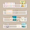 Four white wall shelves are mounted on a light brown wall, displaying books and decorative items. Produktbild-Vorschau
