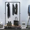 A clothing rack with garments, a handbag, and shoes displayed in a storefront. Náhled obrázku produktu