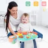 A mother and baby are playing with a green and blue activity table. Podgląd zdjęcia produktu