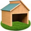 A wooden dog house or mower garage sits on a circular patch of green grass against a white background. Voir les images du produit