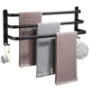 A black aluminum towel rack with three bars, holding three different towels and a bath puff. Anteprima dell’immagine prodotto