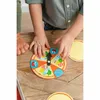 Children's hands playing with a pizza-themed spinner toy on a wooden table. Podgląd zdjęcia produktu