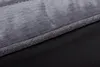 A close-up view of the edge of a dog bed, showing the transition between the gray fabric top and the black bottom. Produktbild-Vorschau