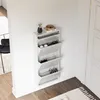A white shoe cabinet with four flip-down compartments is mounted on a white wall next to a white door. The cabinet contains shoes. A small potted plant and a decorative bowl are on top of the cabinet. Náhľad obrázku produktu