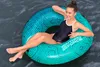 A young person is relaxing in an inflatable tube on the water. Anteprima dell’immagine prodotto