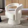 A fluffy, cream-colored armchair is shown in a room setting with a wooden cabinet in the background and a rug on the floor. Anteprima dell’immagine prodotto