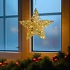 A decorative star light hanging in a window at night, with Christmas decorations below. Anteprima dell’immagine prodotto