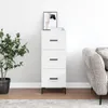 A white sideboard with three drawers is shown in a room with a plant and a couch. Náhľad obrázku produktu