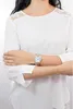 A woman wearing a white blouse and a silver watch on her left wrist. Náhľad obrázku produktu
