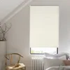 A bedroom scene with a window covered by a beige pleated blind, a wooden chair with books, and pillows on a bed. Produktbild-Vorschau