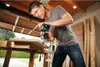 A man is using a router tool on a piece of wood in a workshop. Anteprima dell’immagine prodotto