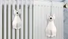 A white ceramic cat ornament hanging on a radiator. Podgląd zdjęcia produktu