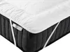 A white mattress topper is placed on a dark gray mattress. The topper has elastic straps on the corners to secure it to the mattress. A small tag with the word "DREAM" is visible on the side of the topper. Náhled obrázku produktu