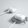Two transparent protective cases for Apple AirPods are shown, one charging via a cable and the other on a wireless charging pad. Produktbild-Vorschau
