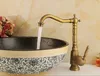A close-up shot of a vintage-style brass faucet running water into a decorative ceramic basin. Anteprima dell’immagine prodotto