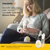 A woman is sitting on a couch, using a Medela electric breast pump. Podgląd zdjęcia produktu