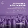 A close-up of a violet jersey fitted sheet, highlighting its texture and elastic edge, with text overlays describing its features. Podgląd zdjęcia produktu