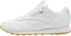 A side view of a white Reebok Classic Leather sneaker with a tan sole. Produktbild-Vorschau